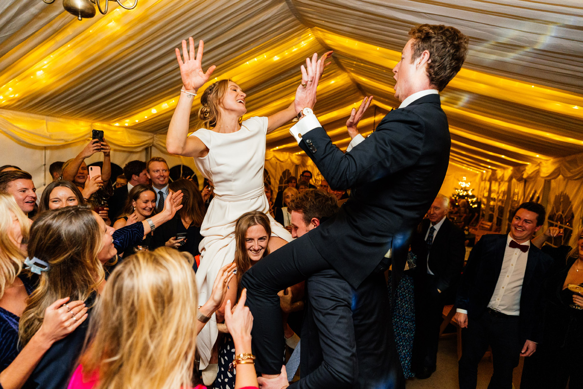Bride and Groom held in the air on the dance floor